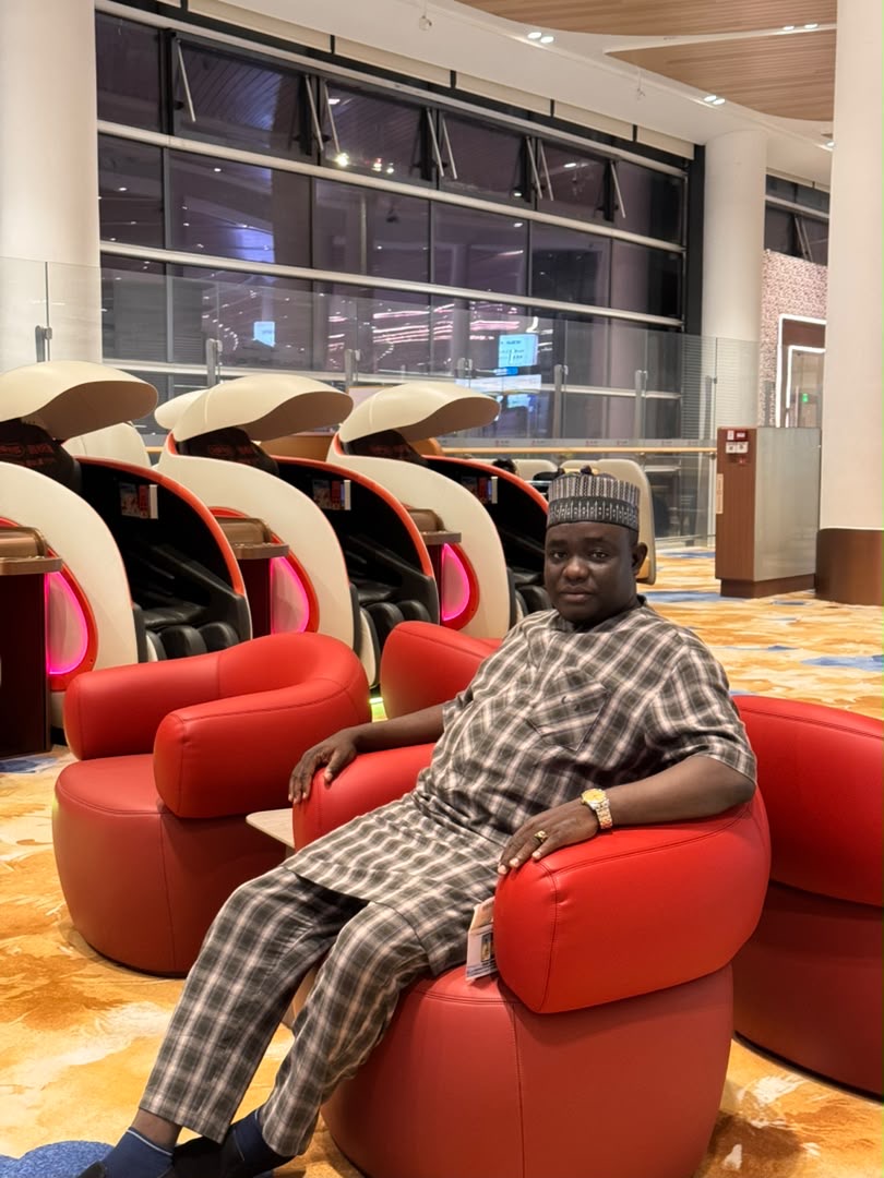 Man wearing traditional attire seated in a modern lounge